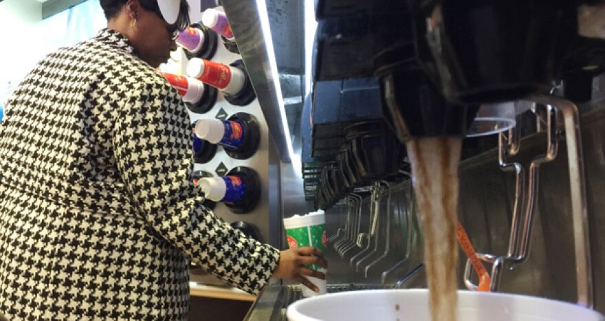 A woman serves herself a fountain drink at the OnCue Express at 1 NE 23rd St. in Oklahoma City Wednesday.