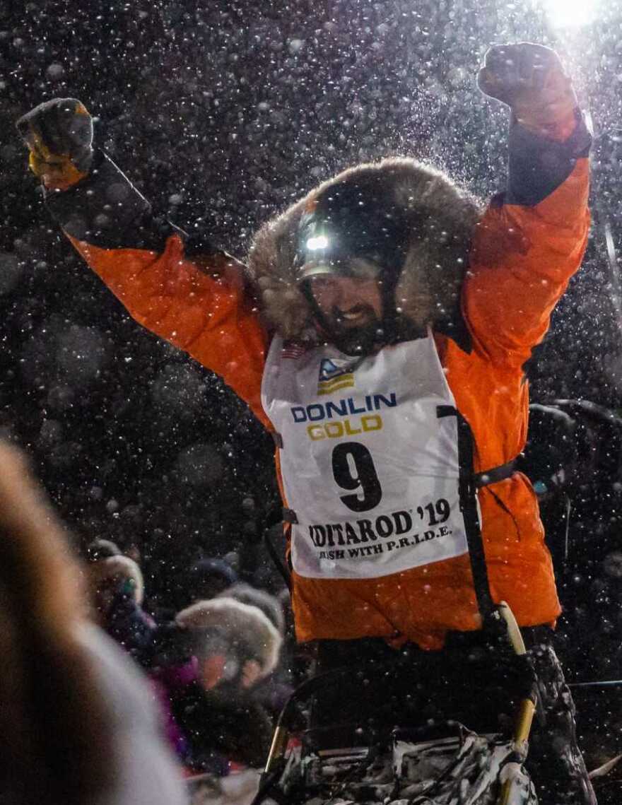 Peter Kaiser celebrates his first-place victory at the finish line of the Iditarod race.