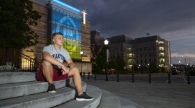 Serhii Kuzmin Jr. sits outside the University of Scranton's Gateway sign