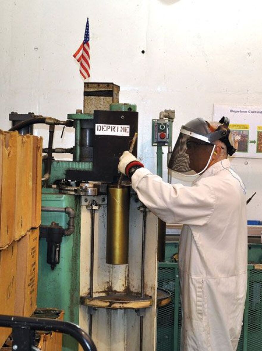 Arthur Begley, a Blue Grass Army Depot explosive material operator, de-primes 105M cartridges to be placed back into military operations. The depot is located on 15 acres south of Richmond