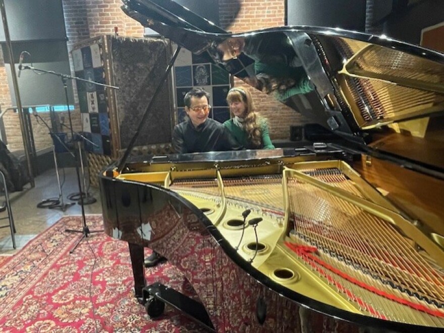 Archie Chen and Rhona Gouldson-Chen sitting together at the piano in SPR's performance studio.