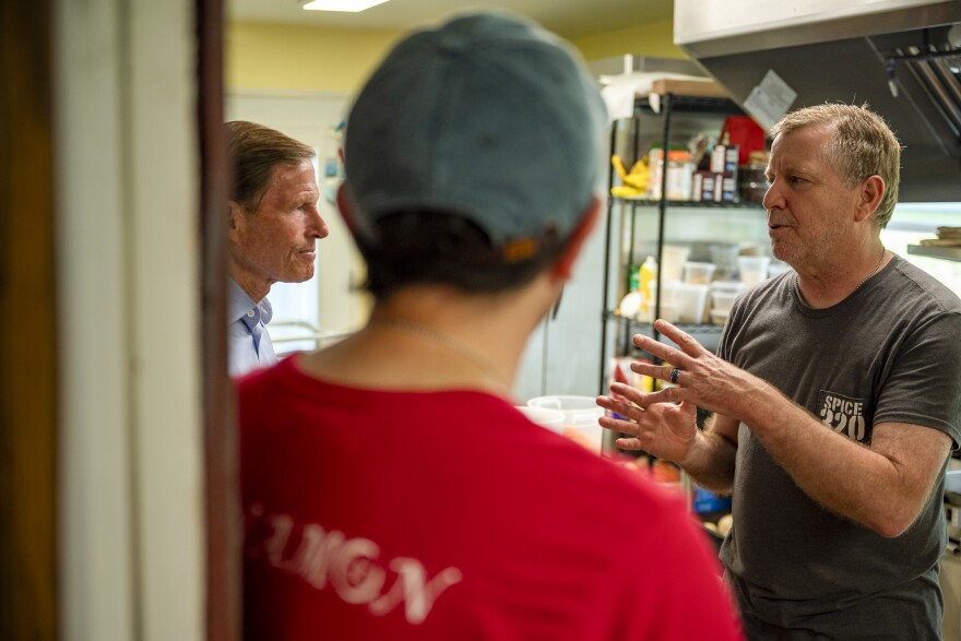 Calling the actions of the town's volunteer fire department "heroic," Spice 320 owner Alan Thayer (right) and business partner Rich Marchesseault meet with Senator Blumenthal (left) in their shop. "They pumped it out all night, all afternoon. Then we slept here on the floor that night; we got a generator from a neighbor," said Thayer.