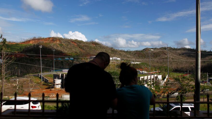 Two evacuees look out from the entrance of the Luis Muñoz Marín public school last week in Barranquitas, Puerto Rico. Many people from Barranquitas have been living in a shelter set up in the school since Hurricane Maria destroyed their homes in September.