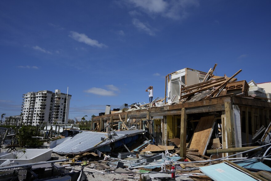 Robert Leisure surveys the wreckage of his business, Getaway Marina, which was destroyed during the passage of Hurricane Ian, in Fort Myers Beach, Fla., Thursday, Sept. 29, 2022. (AP Photo/Rebecca Blackwell)