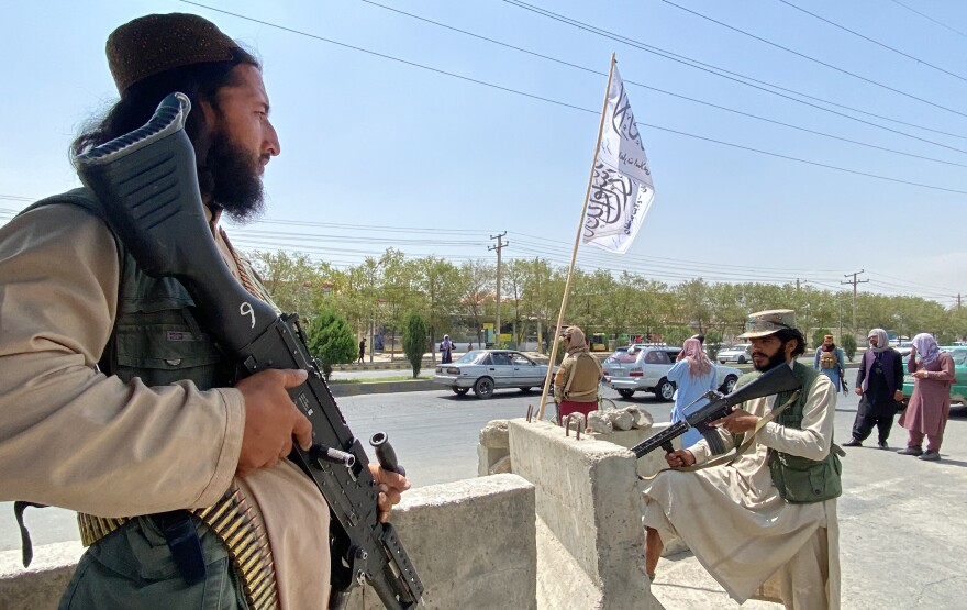 Taliban fighters stand guard at an entrance gate outside the Interior Ministry in Kabul on Tuesday.