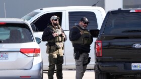 Federal agents stand outside a warehouse as federal officials tour the facility to consider repurposing it as an ICE detention facility, Thursday, Jan. 15, 2026, in Kansas City, Missouri.