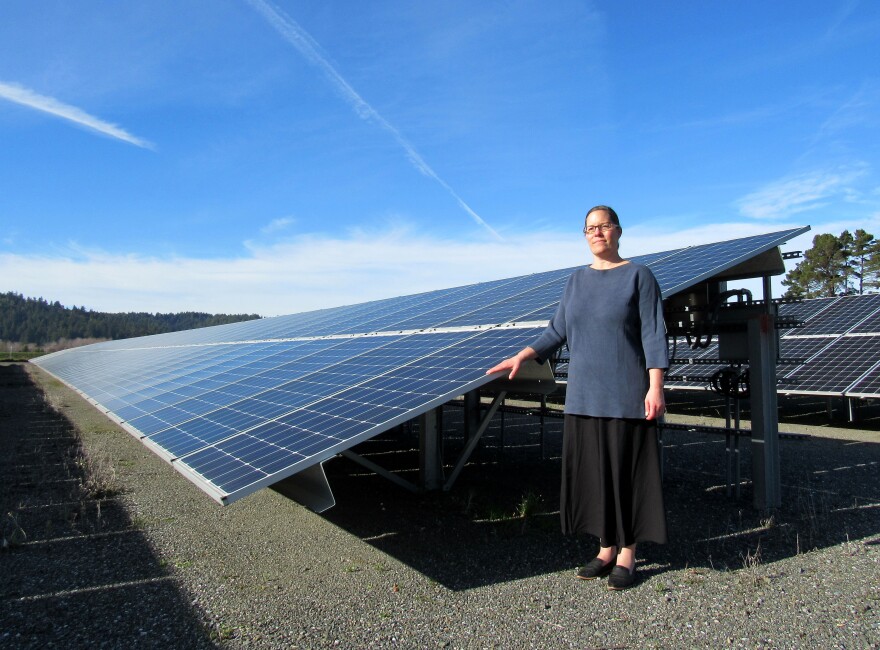 Photo of woman standing next to solar panels