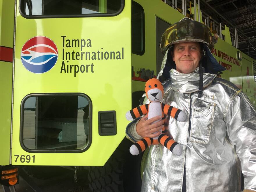 Hobbes poses for a photo with a member of the airport's tarmac emergency crew. The tiger was safely reunited with his young owner — along with a photo album of his exploits.