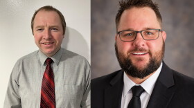Two photos are placed next to each other. A middle aged white man is in the left photo. He wears a grey button down shirt with a red and black diagonal striped tie. He has short brown hair and eyebrows and he's standing against a white wall. A younger looking white man is in the photo on the right. He has brown hair, a mustache and a clean cut looking beard. He is wearing a dark blue dress coat, a dark blue tie and a white button down shirt. The background has faded dark blues, tans and greys.