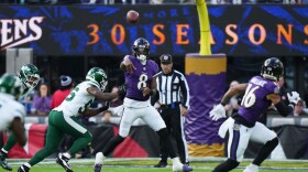 Baltimore Ravens quarterback Lamar Jackson (8) throws under pressure from New York Jets linebacker Quincy Williams (56) during the first half of an NFL football game, Sunday, Nov. 23, 2025, in Baltimore. (AP Photo/Stephanie Scarbrough)