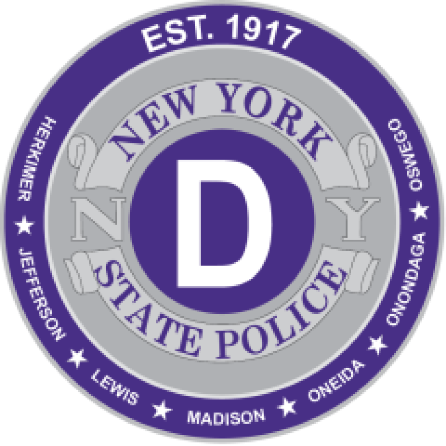 Purple and gray circular emblem of the New York State Police Department, Troop D, covering Herkimer, Jefferson, Lewis, Madison, Oneida, Onondaga, and Oswego Counties