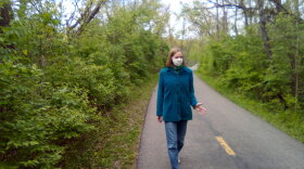 Photo of Jennifer Hambric walking with mask on waving.