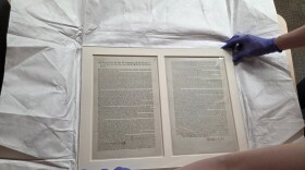 The framed original copy of the Northwest Ordinance is unwrapped from white tissue paper