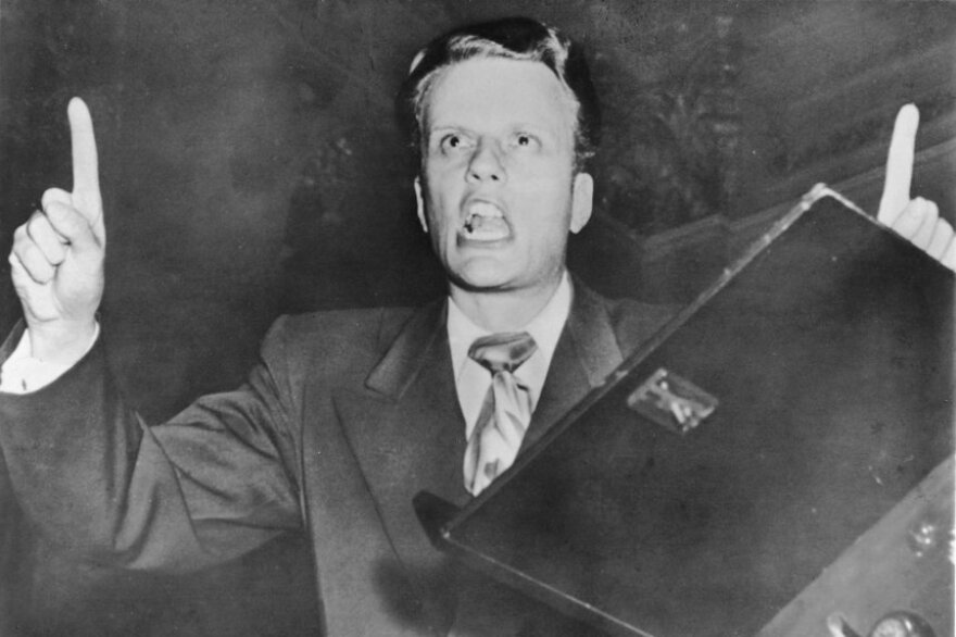 Graham preaches in the early 1950s. Over his career, he preached to more than 200 million people in 185 countries, radically changing the face of born-again Christianity.