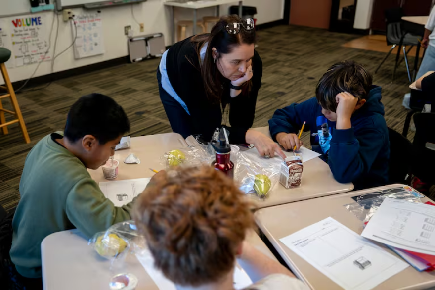 Julie Schaffner helps a student in her fifth grade class at Wascher Elementary School in Lafayette, Ore., on Wednesday, Oct. 15, 2025.