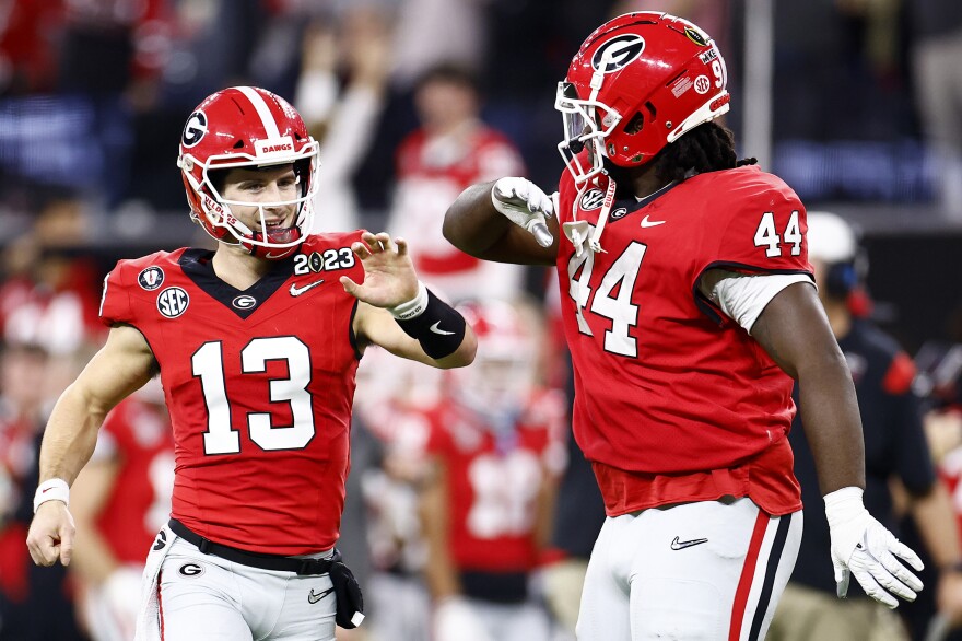 Quarterback Stetson Bennett #13 of the Georgia Bulldogs reacts after a touchdown pass in the first quarter against the TCU Horned Frogs in the College Football Playoff National Championship game on January 09, 2023.