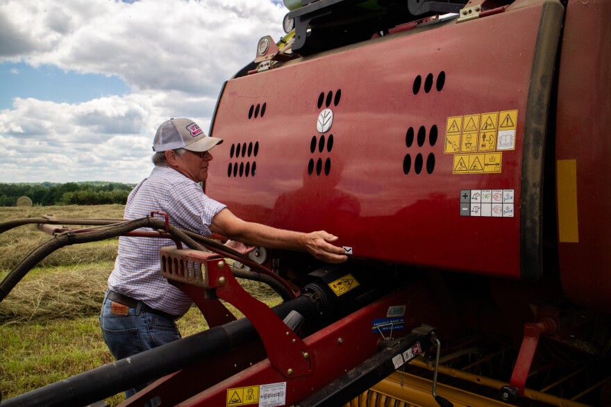 Michigan soybean farmer Bob Thompson opens up his hay baler to inspect the spool of twine on June 22, 2026. While President Trump lowered tariffs on farm machinery, it may not make much of a difference for farmers or retailers.