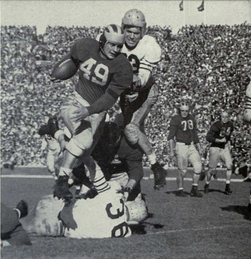 The University of Michigan's Bob Chappuis hurdling a tackler.