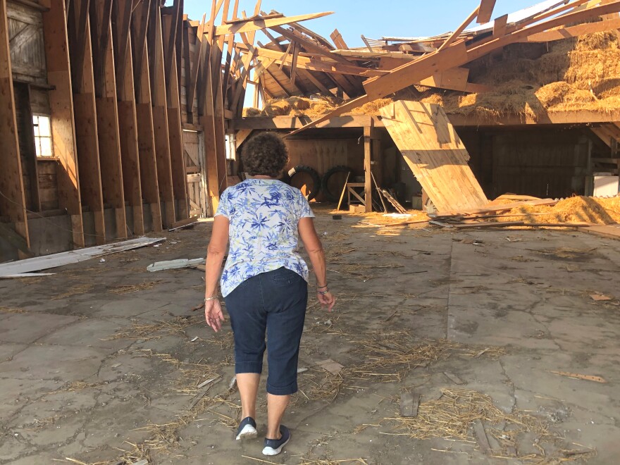 Judi Hertle walks through her partially collapsed barn at her family's century farm outside Vinton.