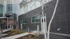 A photo of the outside of the Alaska state crime lab in Anchorage, a modern building with a grey stone and glass facade.