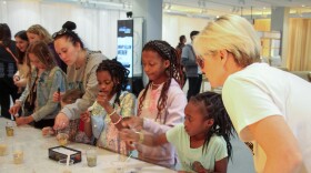 Grace, Abigail and Victoria Fields (left to right) make galaxy-in-a-bottle keychains as their mom, Alex, looks on.