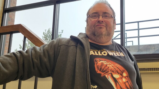 Close-up of a man on a staircase wearing a Halloween movie shirt