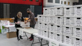 Poll workers Angela and Zach Achten check-in a box of absentee ballots in the gym at Sun Prairie High School on November 3, 2020 in Sun Prairie, Wisconsin. (Andy Manis/Getty Images)