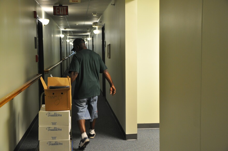 Van Tyler delivers boxes of frozen meals to residents of an apartment building in Jennings.