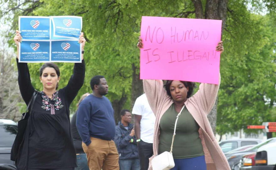 Demonstrators with signs gathered outside CVE Technology in Allen during the ICE raid.