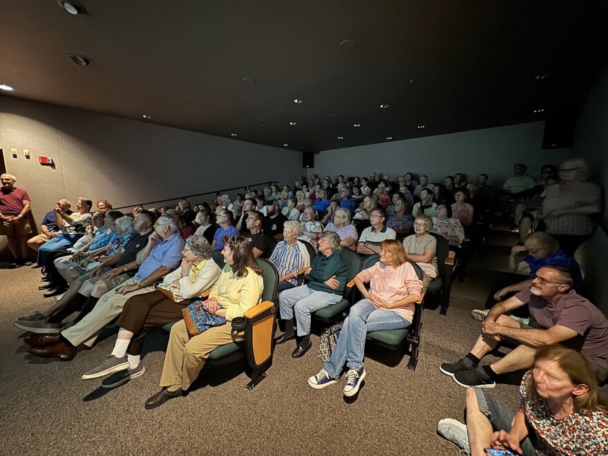 More than a hundred people came to a recent History Speaks lecture on Lakemont Park, held in the auditorium at the Railroaders Memorial Museum in Altoona. Several people are sitting on the stairs or standing against the walls. 