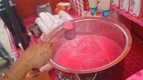 A vendor in Old Delhi mixes a pink beverage of Rooh Afza diluted with milk.