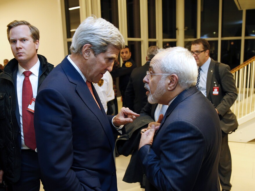 U.S. Secretary of State John Kerry (left) speaks with Iranian Foreign Minister Mohammad Javad Zarif after the IAEA verified that Iran has met all conditions under the nuclear deal.