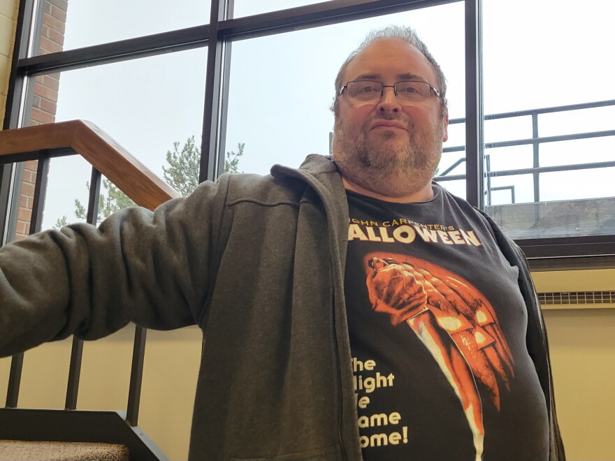Close-up of a man on a staircase wearing a Halloween movie shirt