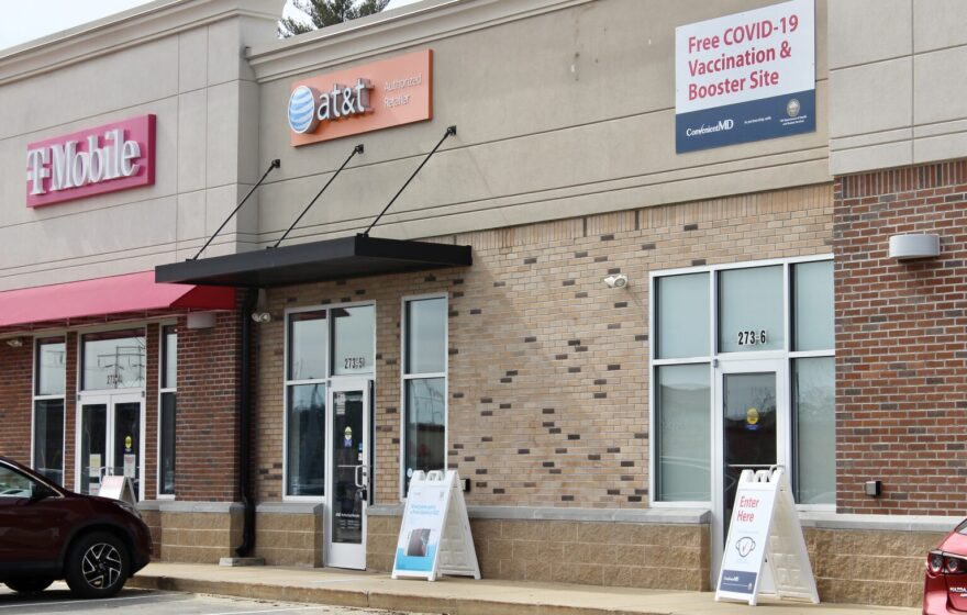 A photo of the outside of a COVID-19 vaccination and booster shot location, next to a T-Mobile and AT&T. 