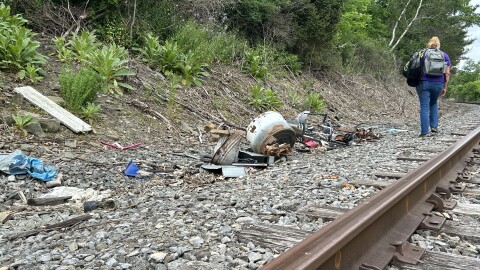 A worker who does homeless outreach walks along train tracks in Corning.