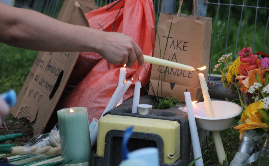 Protestors light candles and leave flowers on a fence near Mechanics Park in Biddeford at a vigil for a 26-year-old man killed by ICE agents July 13, 2026.
