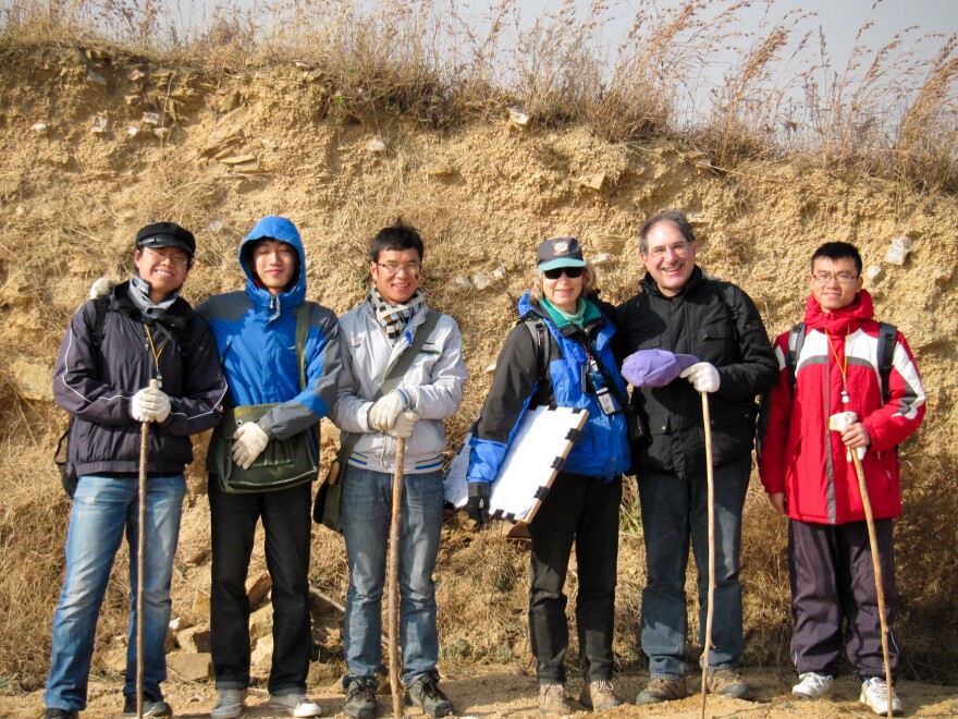 Behind archaeologists Gary Feinman, Linda Nicholas and their crew of graduate student researchers, a cut-away portion of the Qi wall reveals its rammed-earth construction.