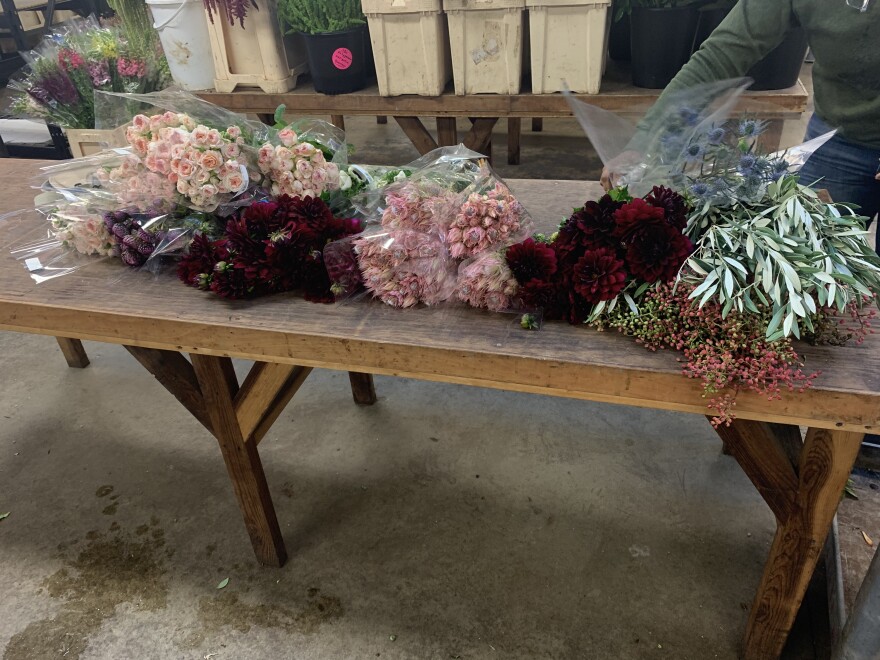 Marbley lays out her selections at the flower market.