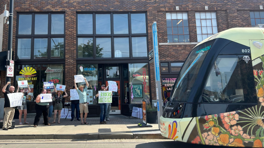 Members of workers' groups and community members show support for streetcar workers with hand-lettered signs outside a River Market coffee shop on the day of the union vote.