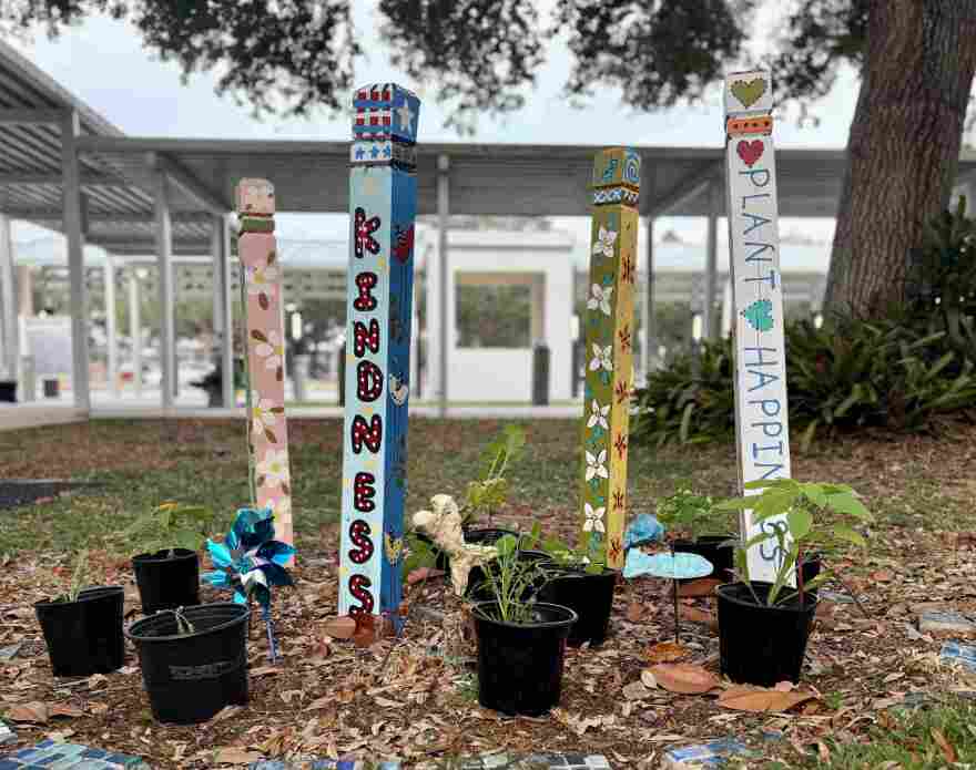 A close-up of potted plants on the ground with colorful sign posts surrounding them