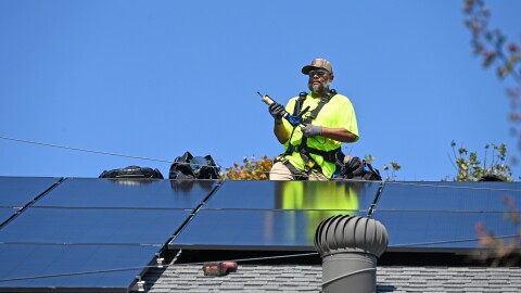 RENU Energy Solutions worker installs a residential solar system on a roof in Davidson.