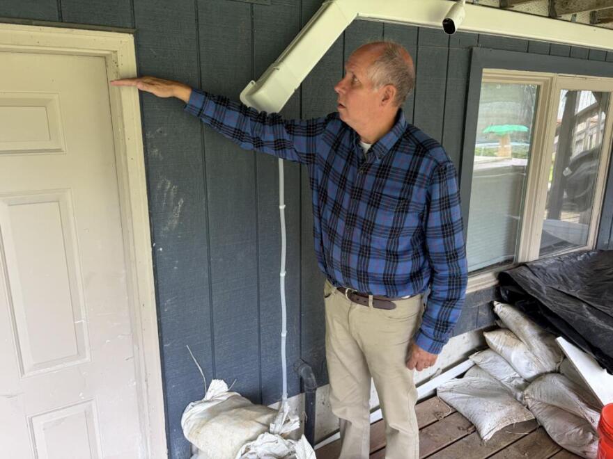 Hours before this years flood began, John Lohrey shows how high the flood waters reached at his Juneau home in 2024. (Peter O'Dowd/Here & Now) 