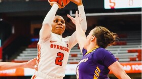 Dyaisha Fair takes a jump shot over an Albany defender with her arm outstretched 