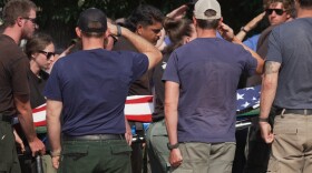 The body of a firefighter who died battling wildfires near the Colorado-Utah border is carried during a procession in Grand Junction, Colo., Monday, June 29, 2026.