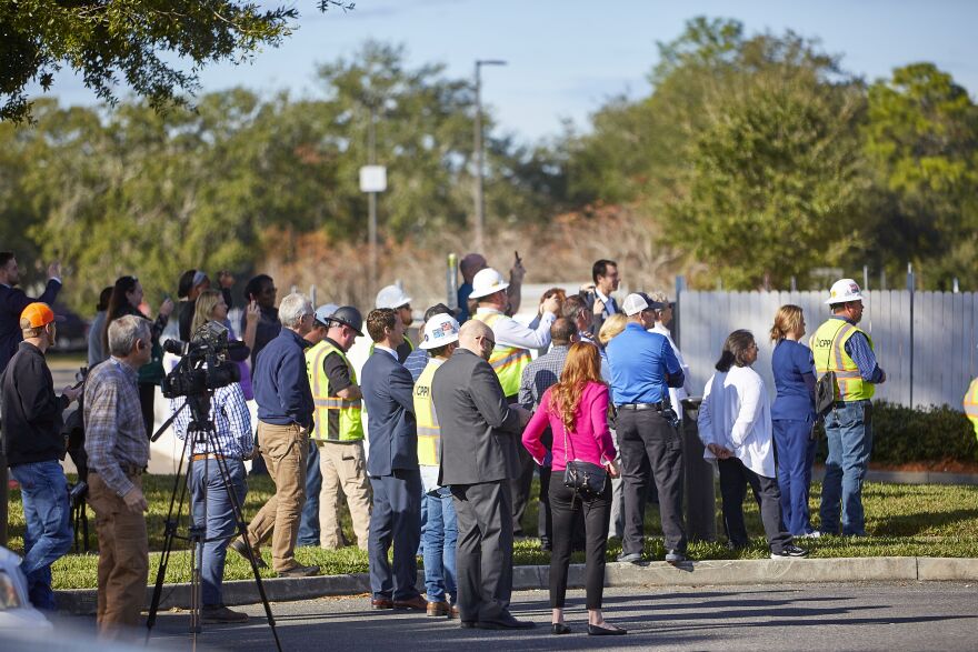 Image shows: Onlookers gather to see the final beam placed for a new tower at the Orange Park Medical Center.