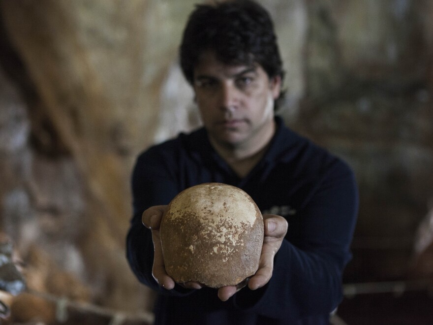 Dr. Omry Barzilai of the Israel Antiquities Authority holds an ancient skull found inside a cave near the northern Israeli city of Nahariya.