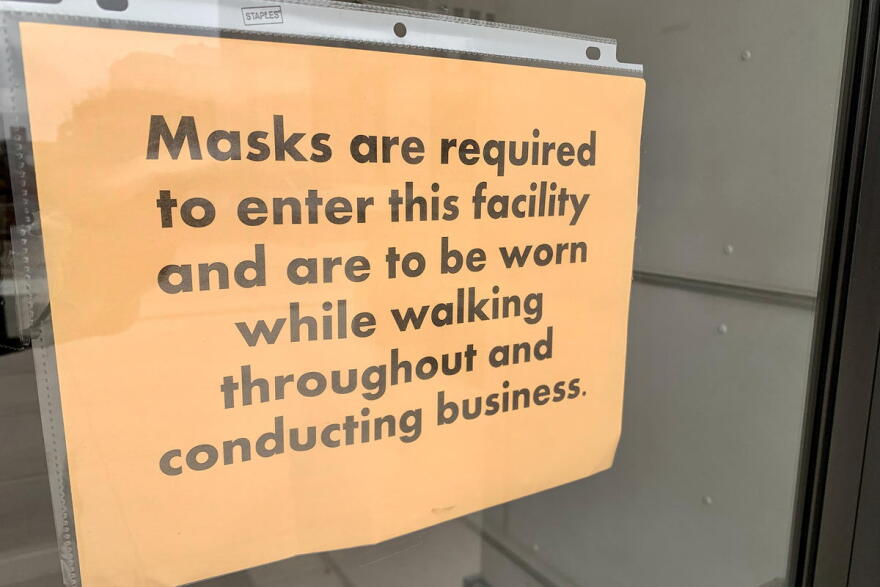 Signs posted at entrances to the Statehouse tell visitors they must wear masks inside.