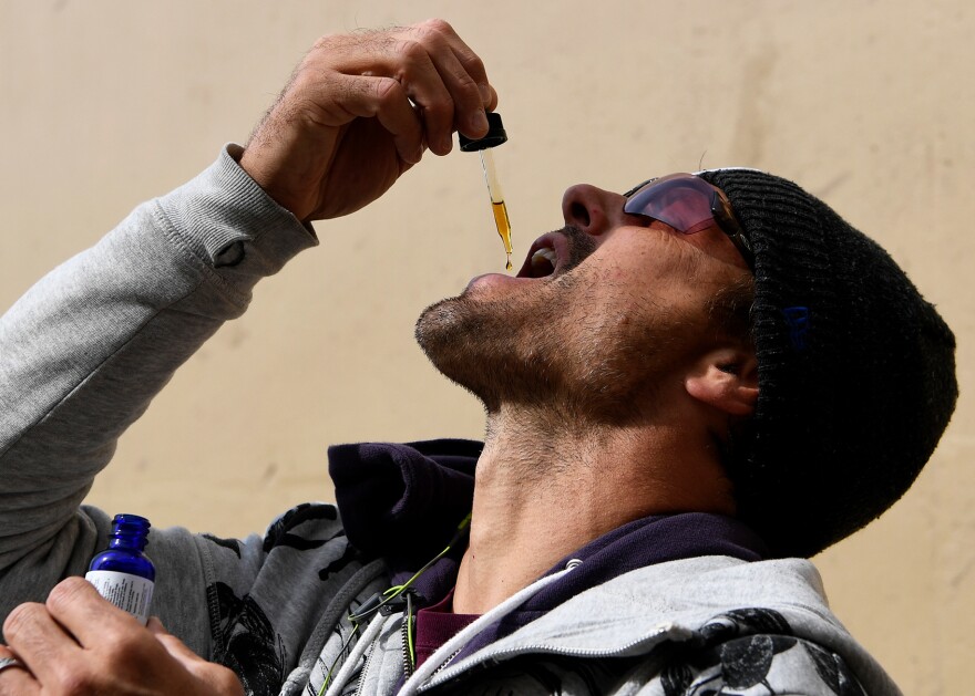 Former Denver Broncos quarterback Jake Plaummer takes a dose of cannabidiol in Colorado in 2016. CBD oil, often dispensed under the tongue with a dropper, has been regulated as a supplement in the U.S., not a medicine. So strength and purity may vary from brand to brand, or even bottle to bottle, scientists say.