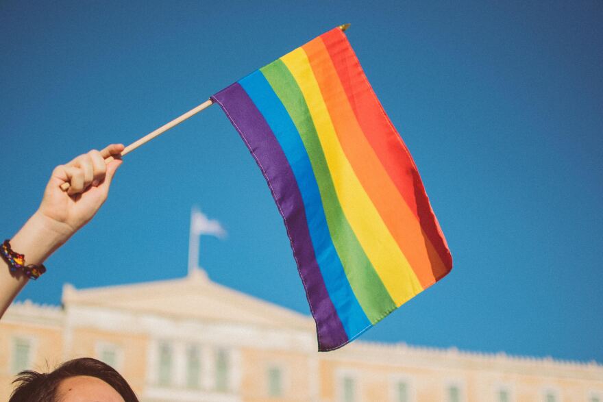 Hand holding rainbow LGBTQ flag