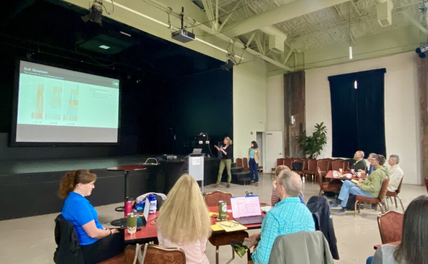 Watershed summit attendees listen intently to the data on soil moisture, and place their own guesses on what certain data points may be.